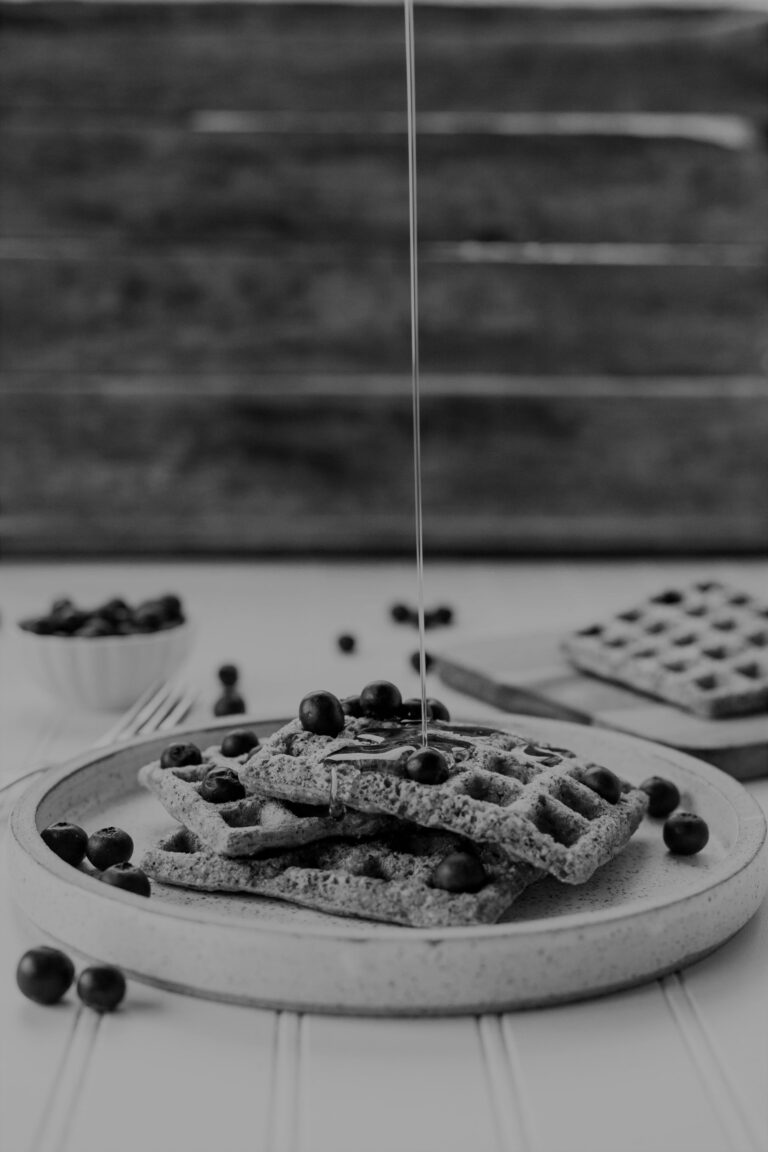 pouring syrup over waffles